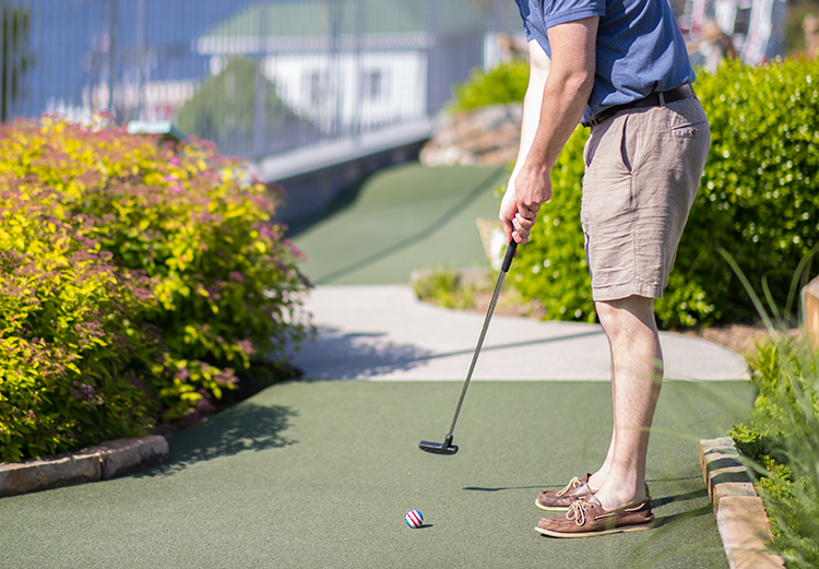 Man lining up a shot at the hole on a golf course.